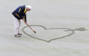 2017-08-06 16_54_00-Man Wearing Blue Jacket Holding a Brown Stick Towards the Heart Drawn on Sand ·
